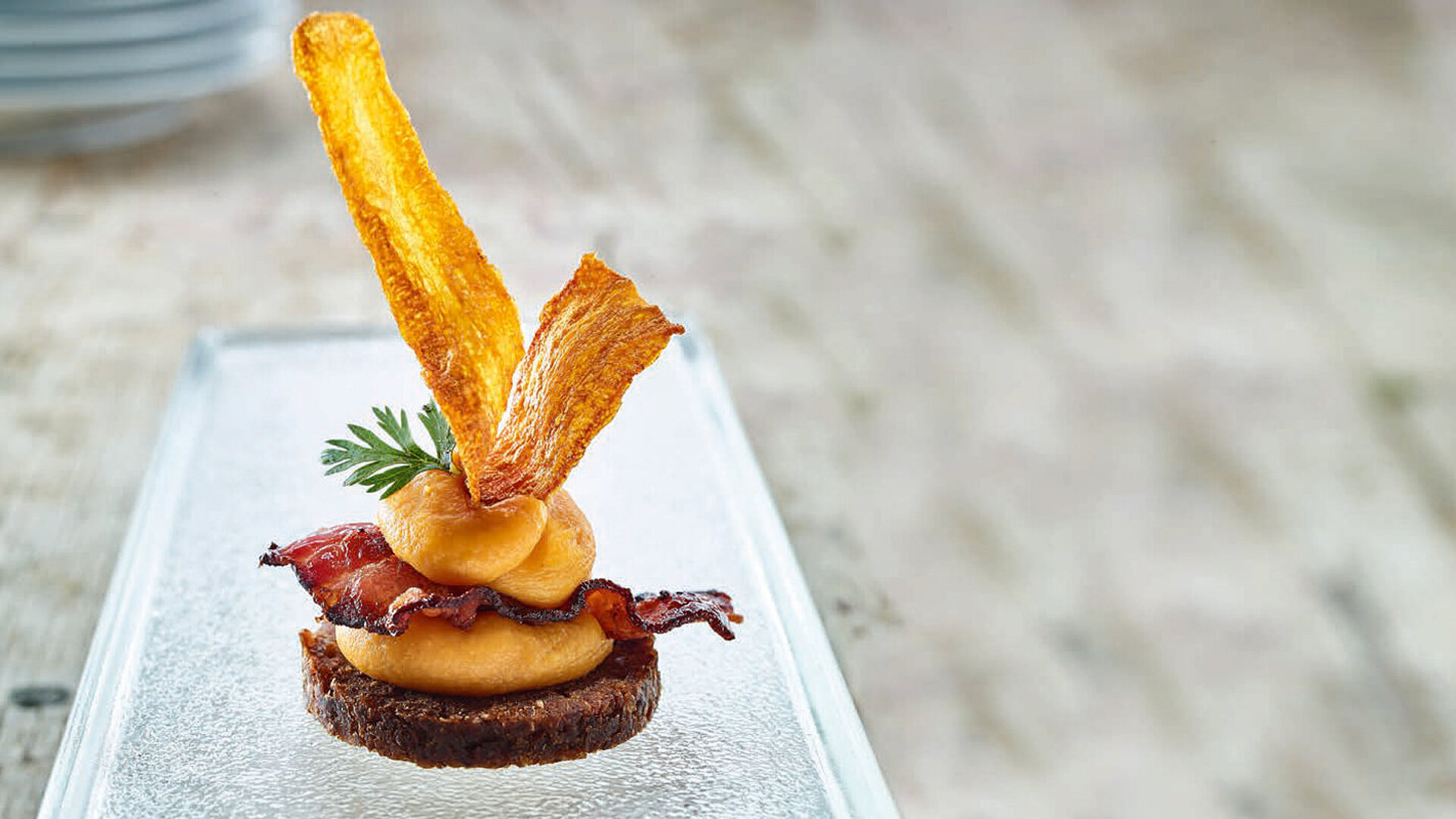 Pumpernickel mit Möhrenpüree, Möhrenchips und Bauchspeck | INTERGAST